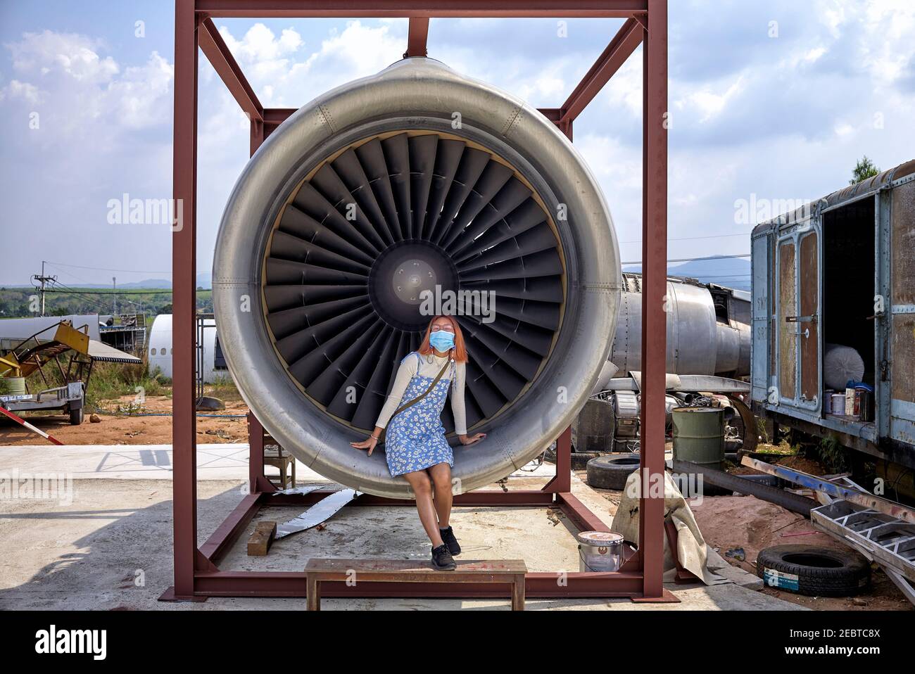 Girl sat inside a jet turbine engine providing human size comparison Stock Photo