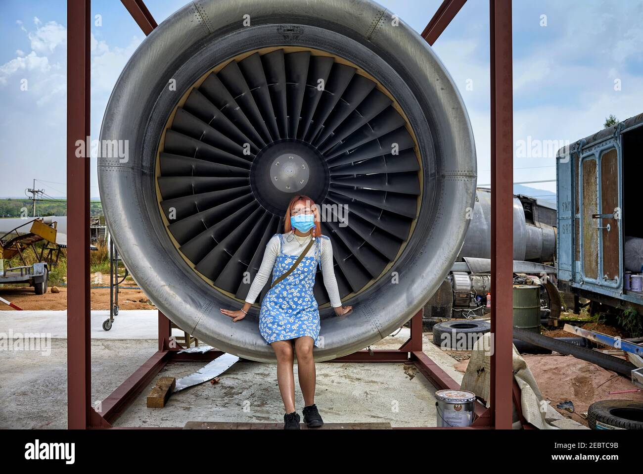 Girl sat inside a jet turbine engine providing human size comparison Stock Photo