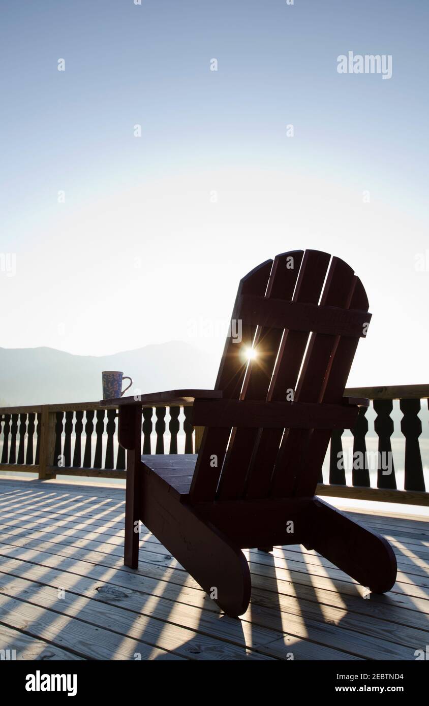 USA, New York, Lake Placid, Adirondack chair on deck by lake Stock Photo