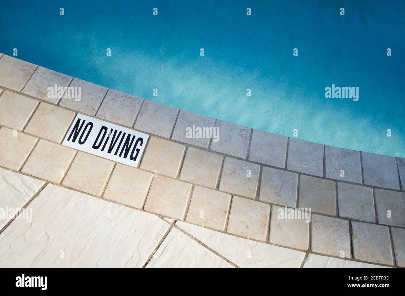 Warning sign at edge of swimming pool Stock Photo