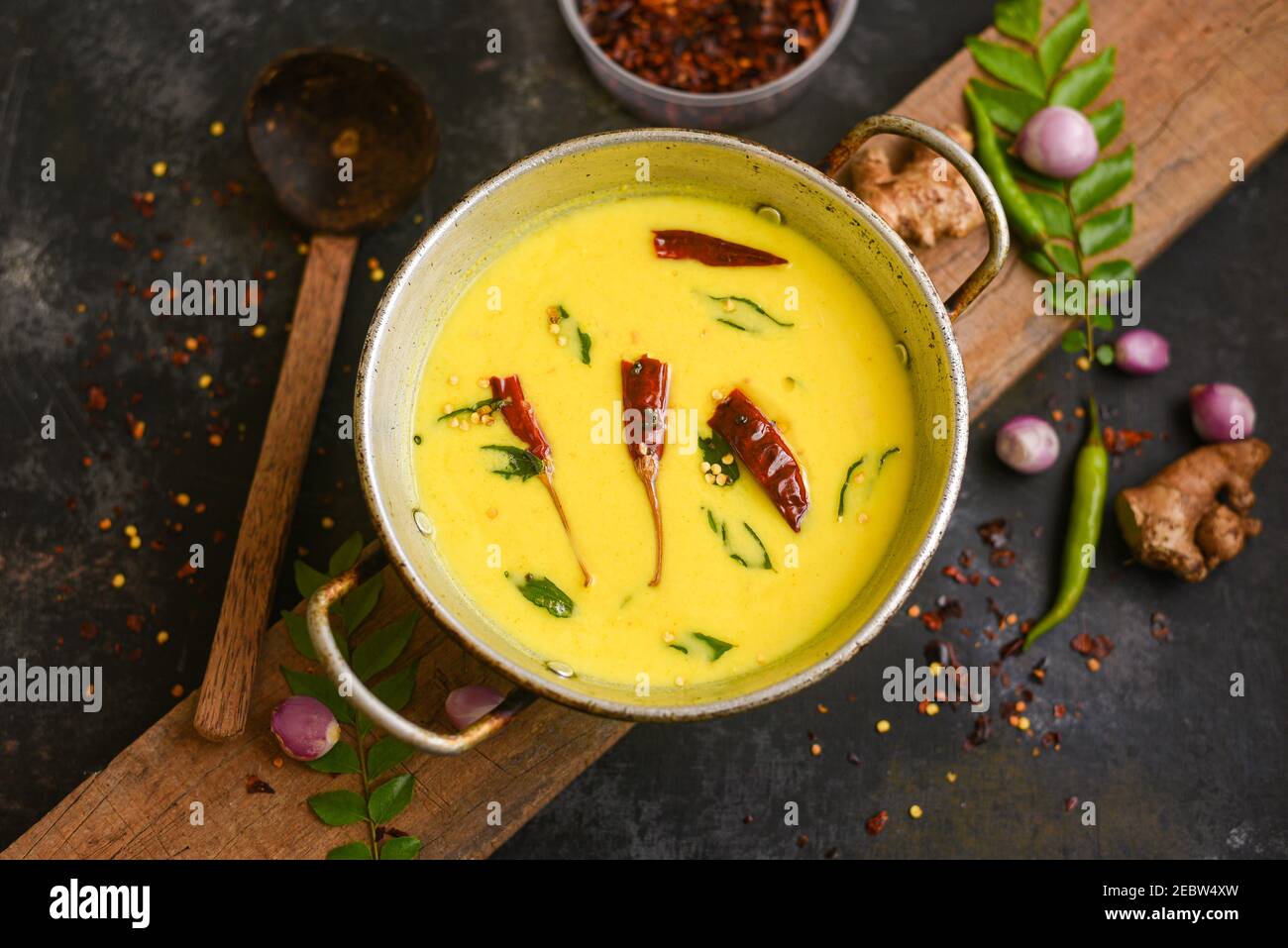 Bowl of homemade sour cream curd yogurt Dahi fresh herbs curry leaf Kerala, India. Dairy product obtained by coagulating milk a process curdling. Stock Photo