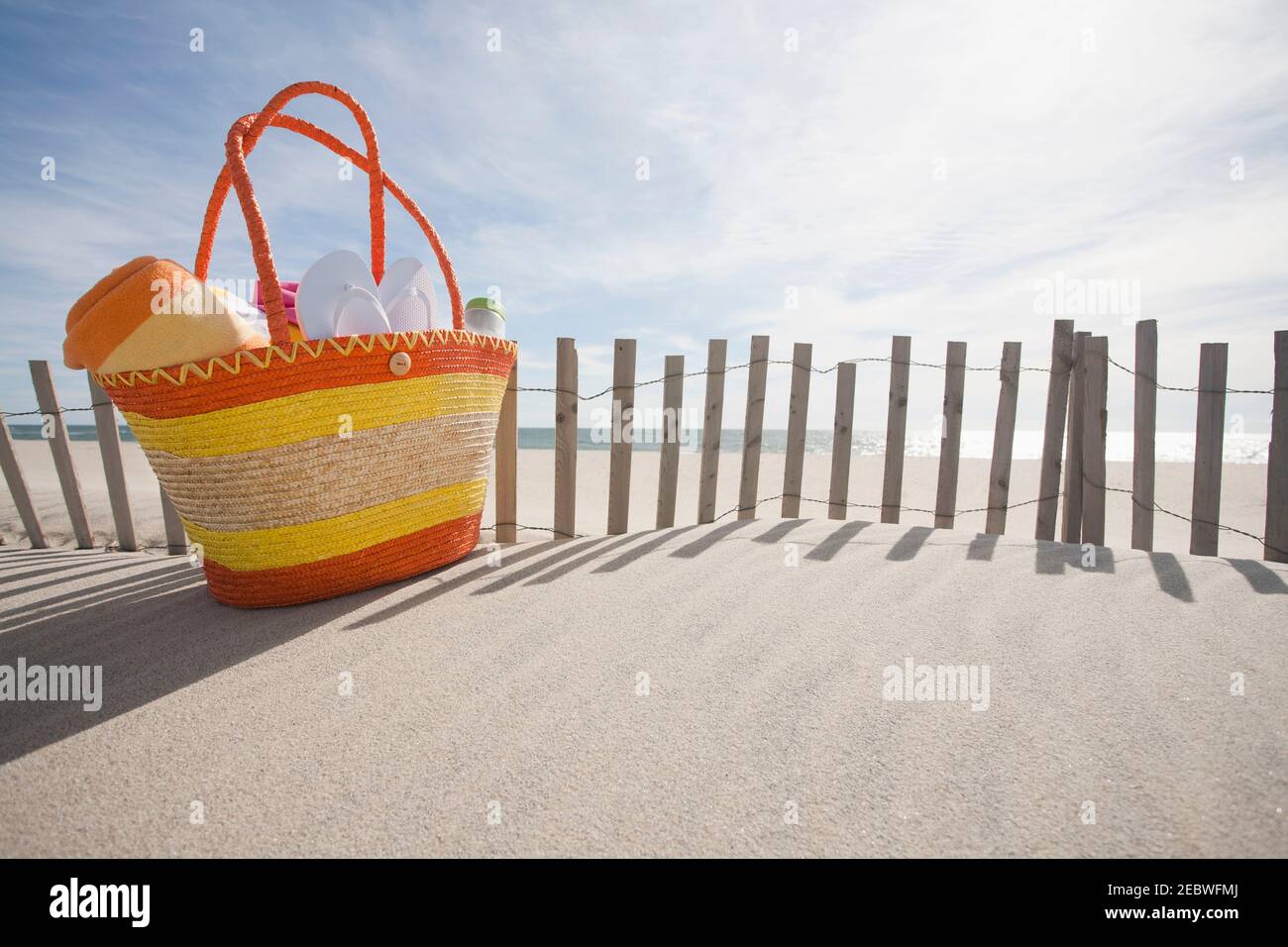 Beach bag with flip-flops on beach Stock Photo