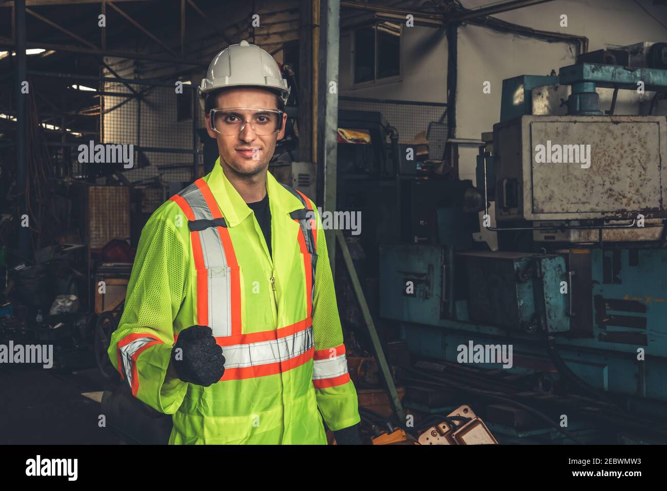 Young skillful factory worker or engineer close up portrait in factory