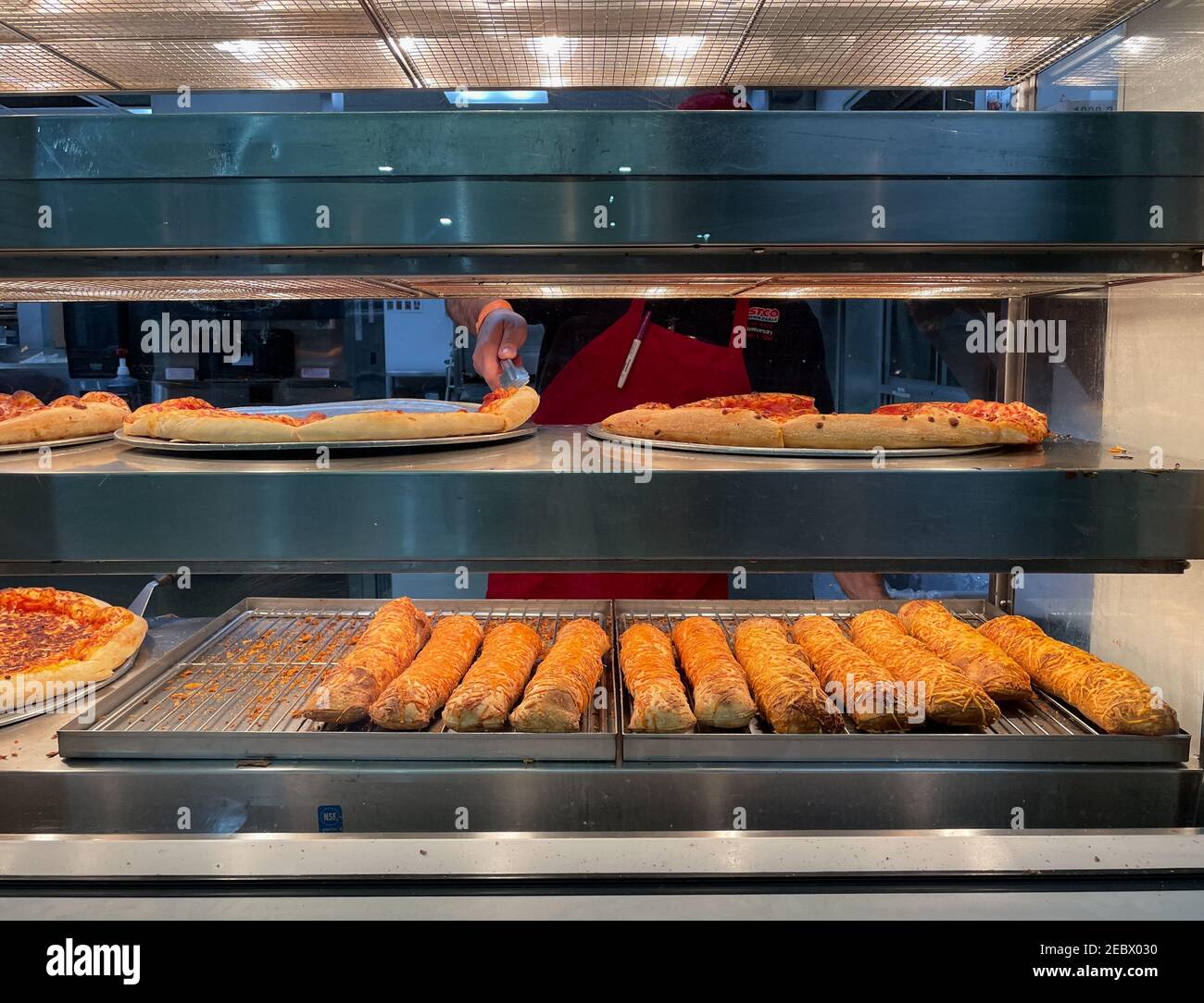 Signal Hill, CA USA - Jan 20, 2021: Close up view of Costco food court with an employee getting the pepperoni pizza from the tray Stock Photo