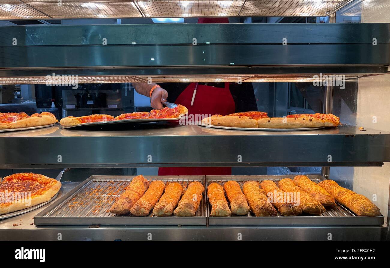 Close up view of food court station with an employee getting the pepperoni pizza Stock Photo