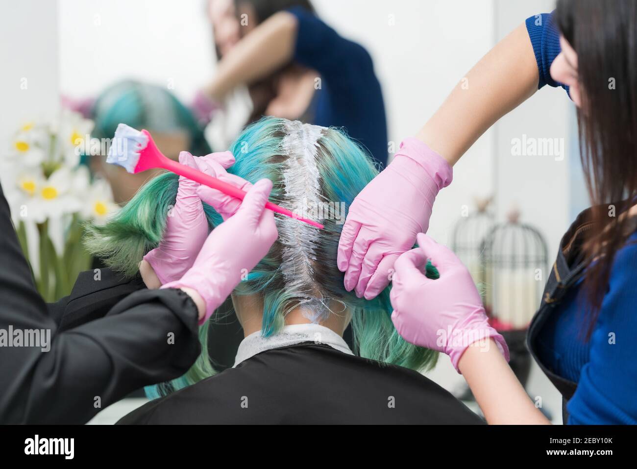 Process of hair dyeing in beauty salon. Two professional hairdressers