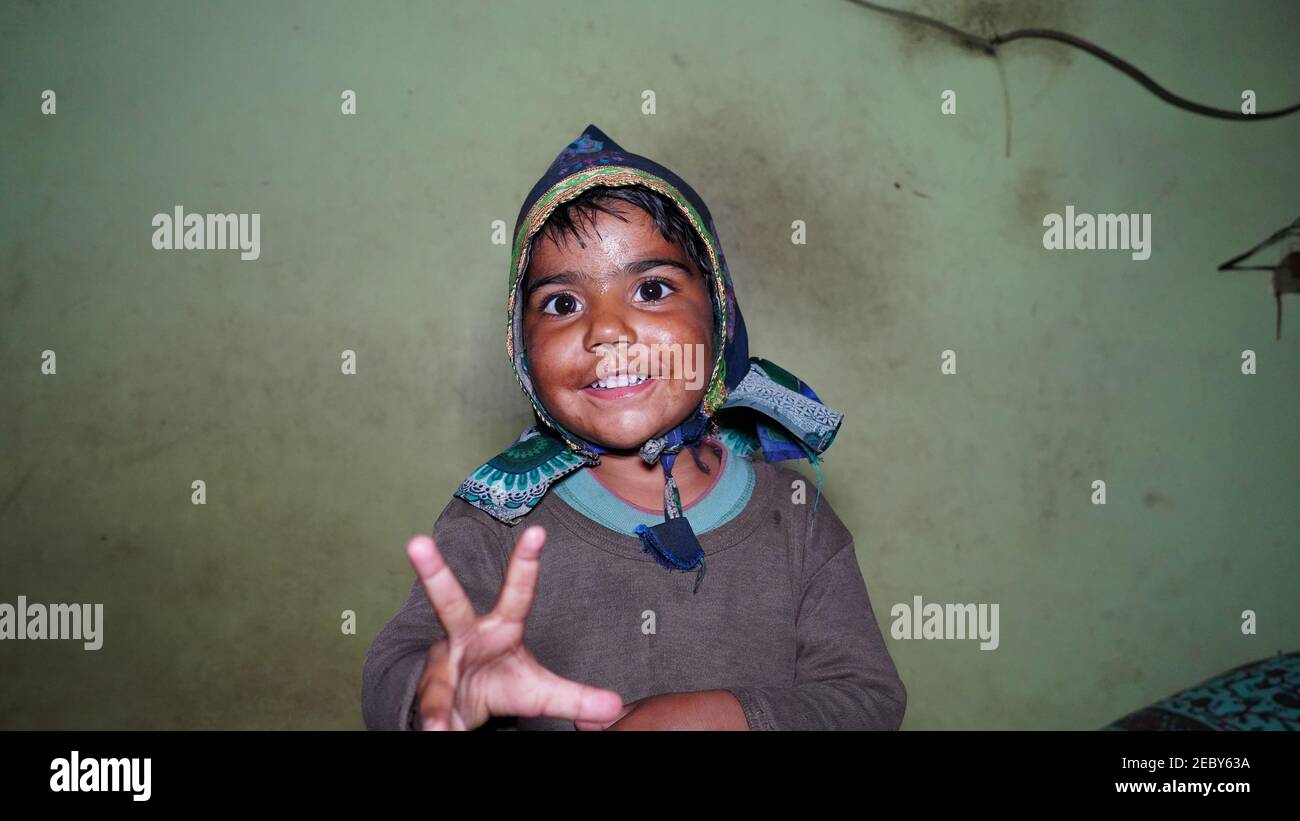 08 February 2021- Khatoo, Jaipur, India. Cheerful little kid wearing hat on head and smiling at camera. Little kid showing white teeth. Stock Photo
