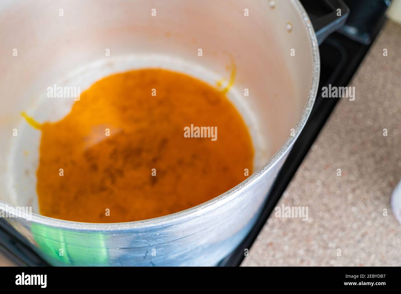 Palm oil warming up melting in pot to prepare Egusi Vegetable soup