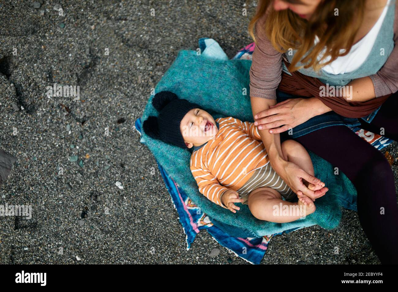 A young mother is on the beach with her baby in the autumn Stock Photo