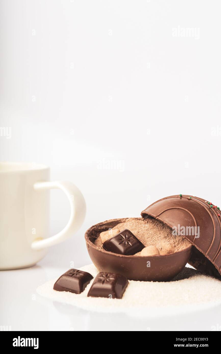 An open cocoa bomb and drinking mug are isolated on a white background Stock Photo