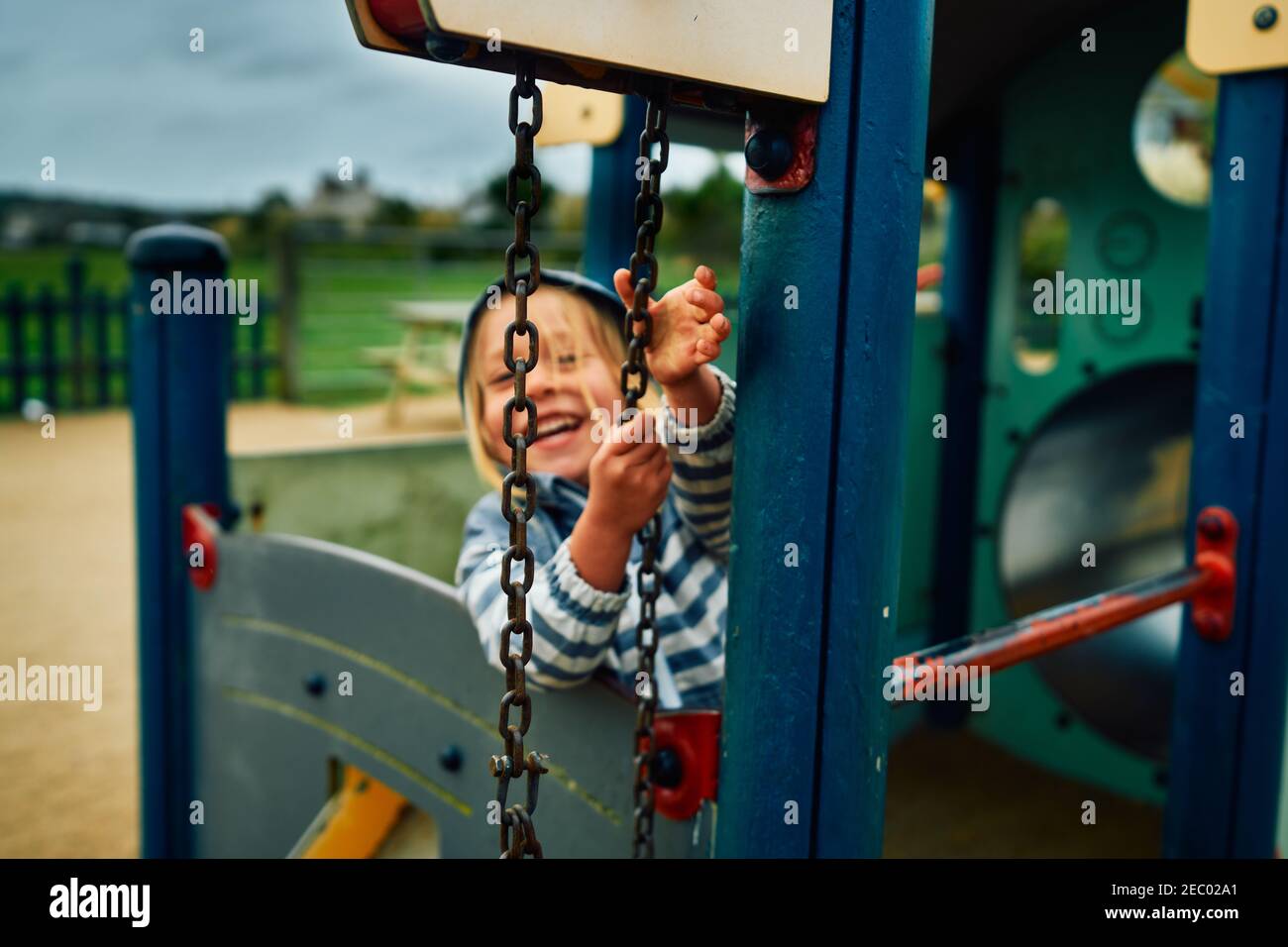 A little preschooler is playing with a pulley at the playground Stock