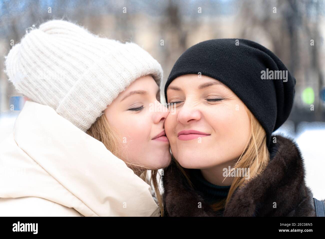 nice teenage girl hug kiss in cheek happy young Caucasian mother show ...