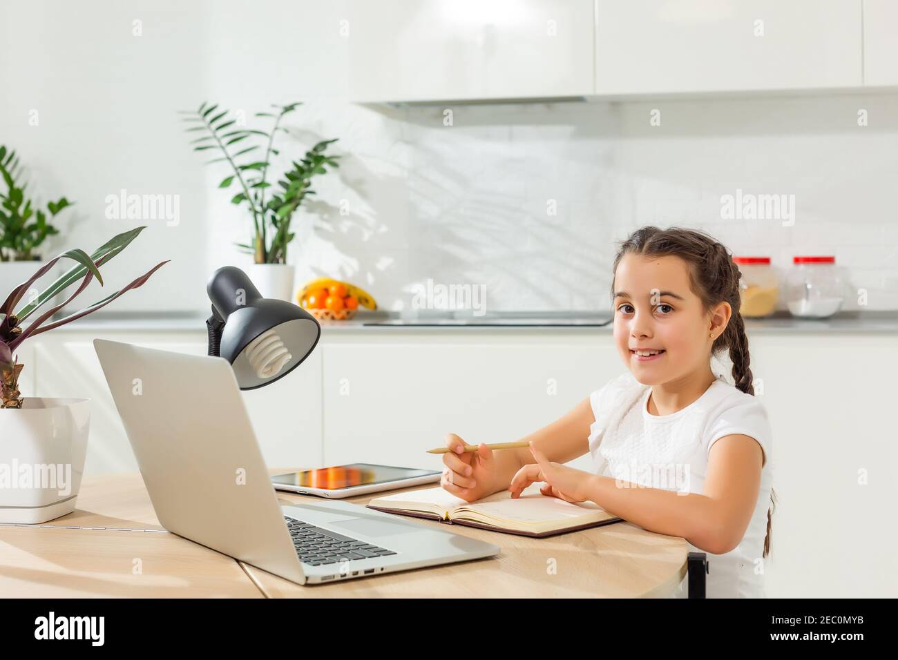 Kids distance learning. Cute little girl using laptop at home ...