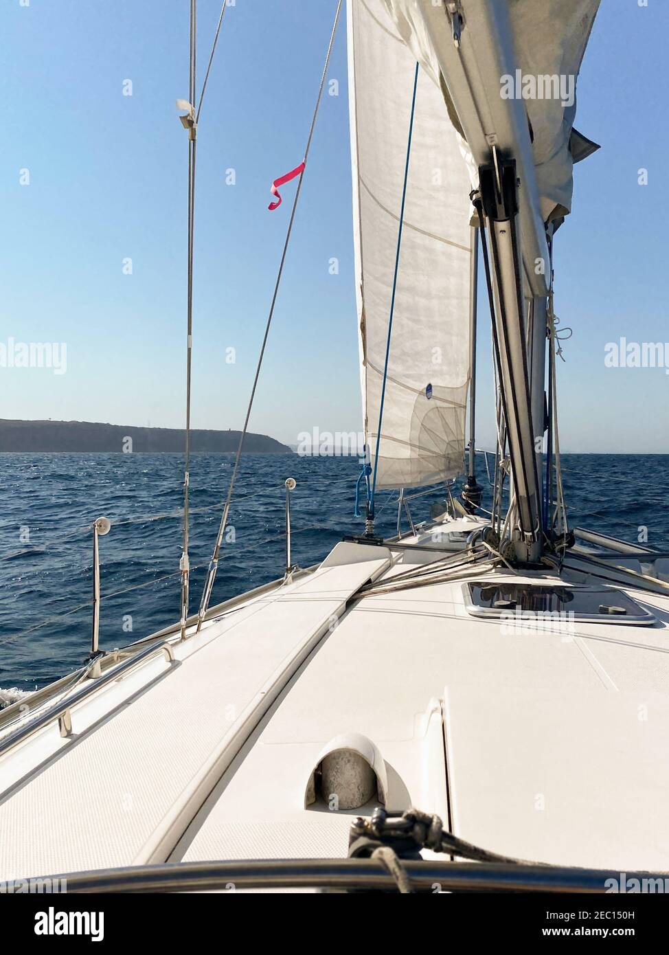 Yacht sailing away from the heads of Sydney Harbor, on a calm and sunny