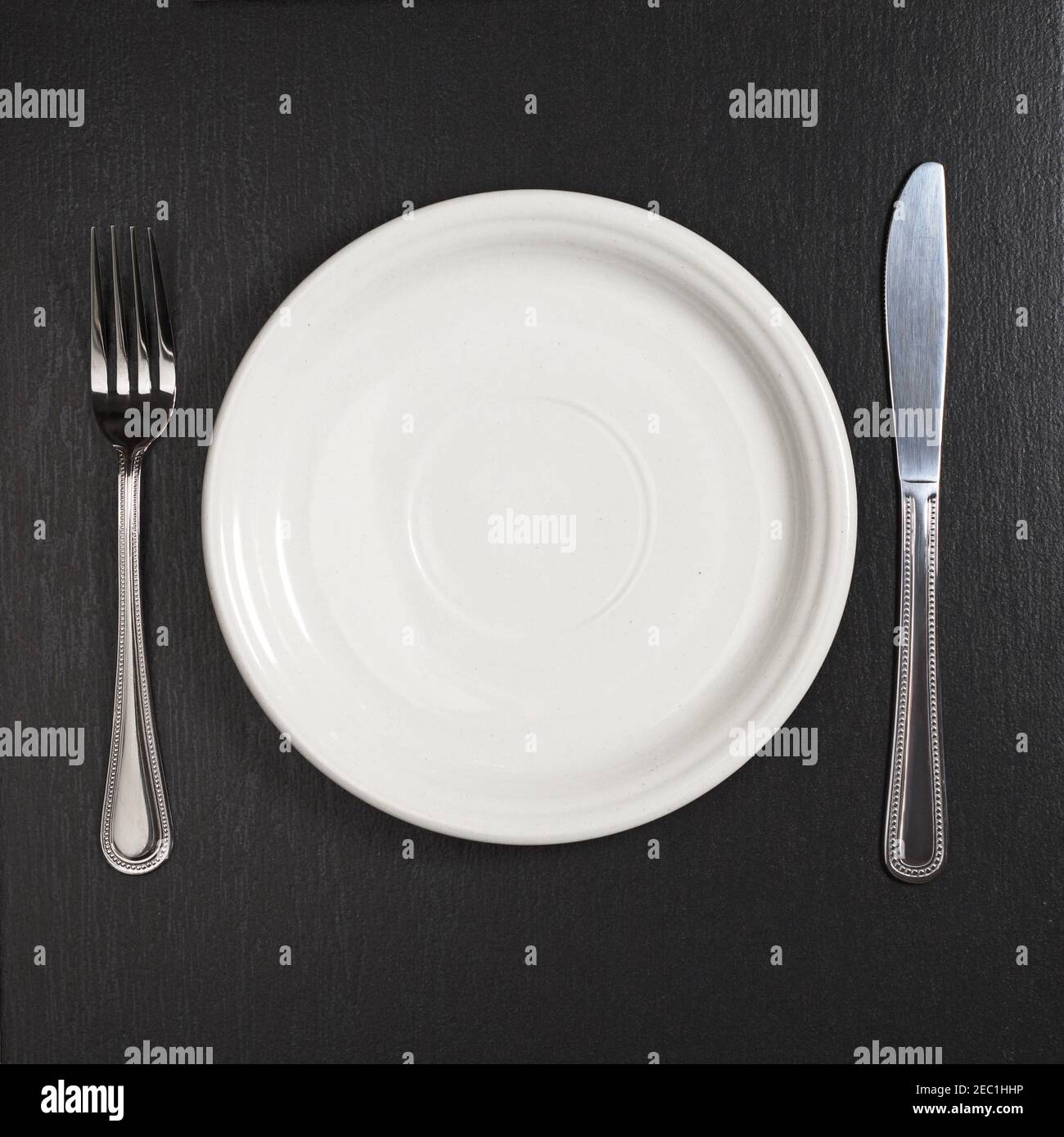 Empty plate on black stone table, top view Stock Photo - Alamy