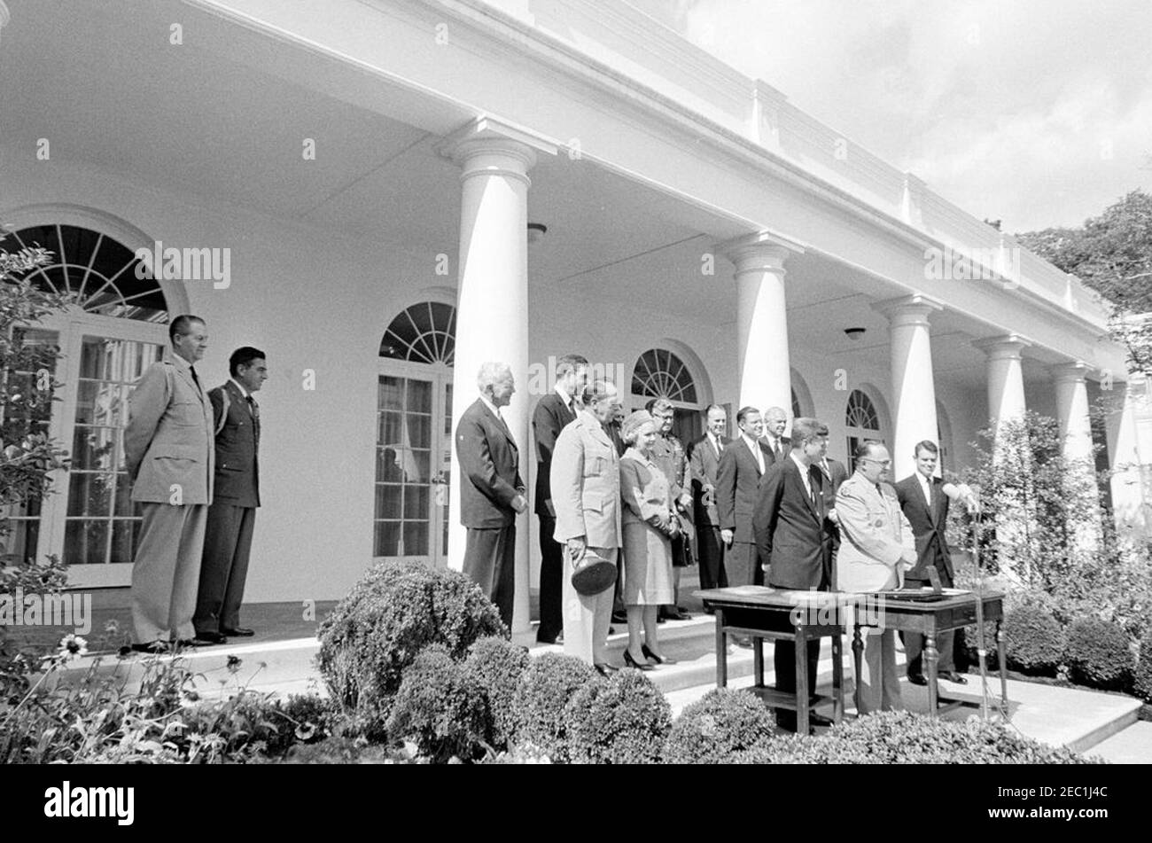 Presentation of the Distinguished Service Medal to Gen. George H. Decker, 12:05PM. Retiring Chief of Staff of the United States Army, General George H. Decker (right, at microphones), delivers remarks after receiving the Distinguished Service Medal (DSM); President John F. Kennedy stands left of General Decker. Also pictured: Military Aide to the President, General Chester V. Clifton; Air Force Aide to the President, Brigadier General Godfrey T. McHugh; Director of the Central Intelligence Agency (CIA), John McCone; Chairman of the Joint Chiefs of Staff, General Lyman L. Lemnitzer; Representat Stock Photo