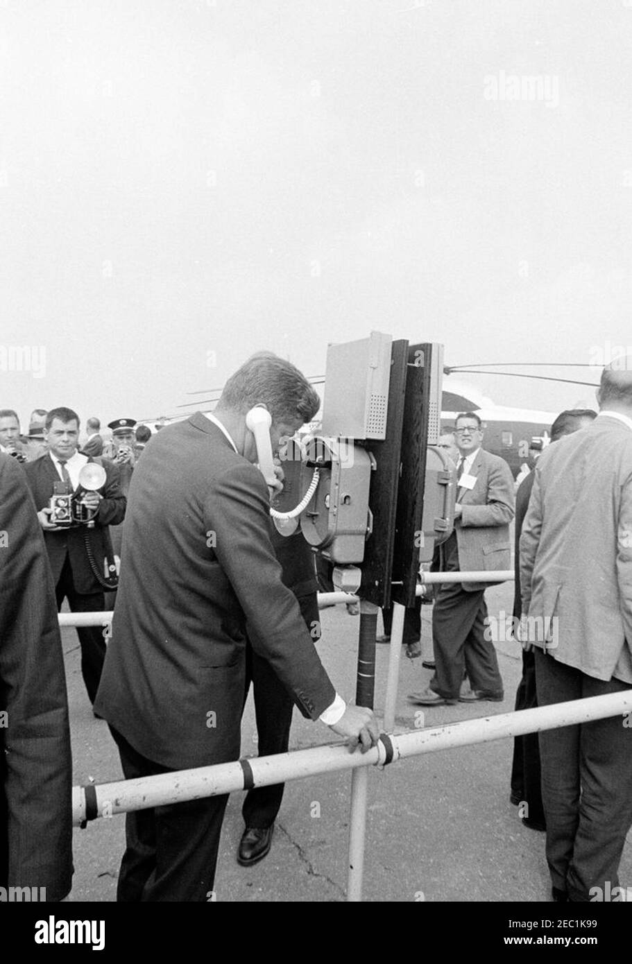 Congressional campaign trip: Detroit, Michigan, remarks at hotel, tour of city, departure. President John F. Kennedy speaks on a telephone prior to his departure from Detroit City Airport for Flint, Michigan, during a congressional campaign trip. Detroit, Michigan. Stock Photo