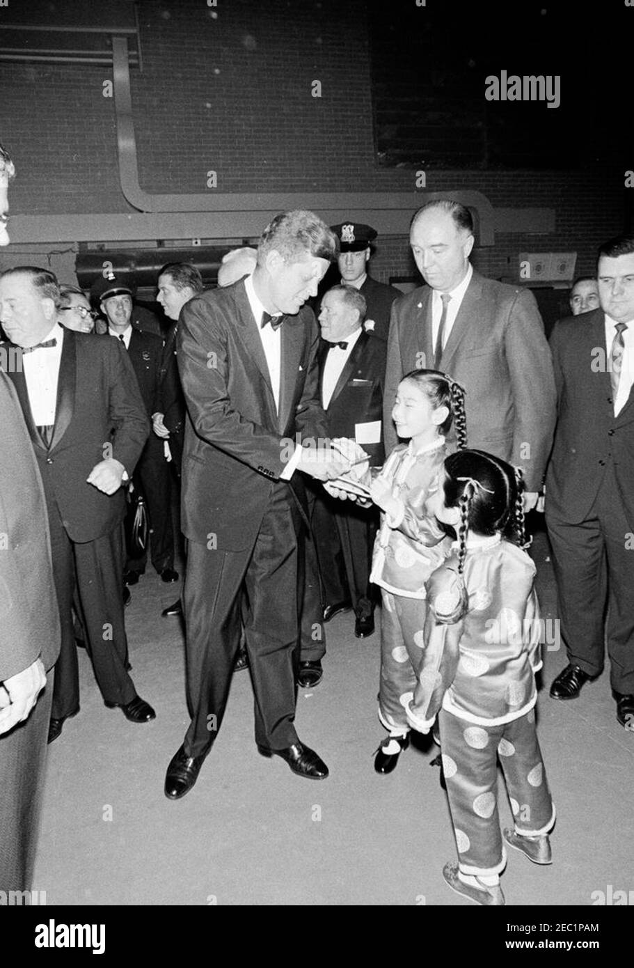 Congressional campaign trip: Chicago, Illinois, arrival, motorcade, address to Cook County Democratic Dinner, address at Aerie Crown Theater. President John F. Kennedy signs an autograph for a young girl outside of McCormick Place in Chicago, Illinois, prior to attending a Cook County Democratic dinner during a congressional campaign trip. Mayor of Chicago, Richard J. Daley, stands at left. Stock Photo