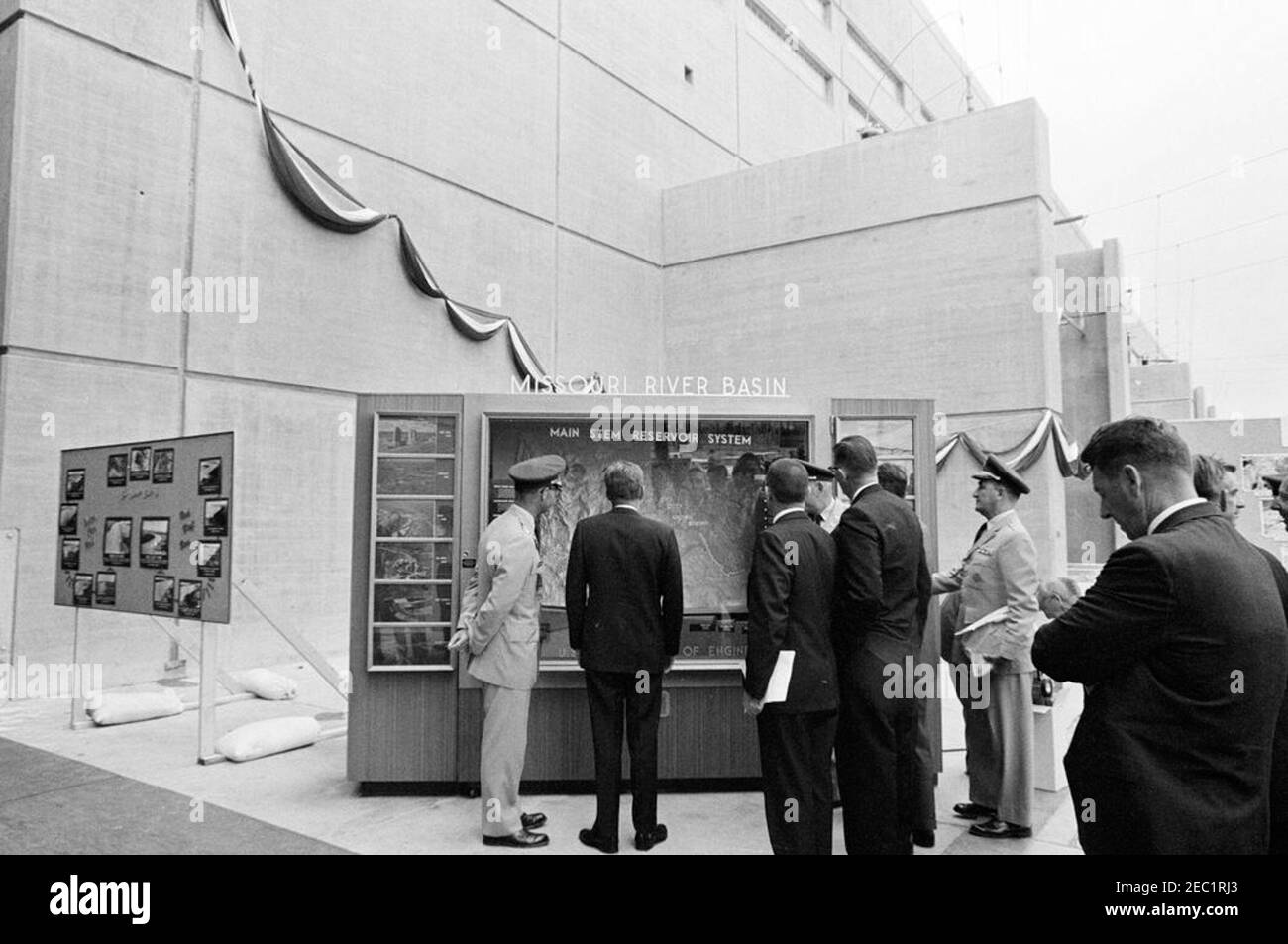 Trip to Western States: Pierre, South Dakota (Oahe Dam), 10:25AM. President John F. Kennedy (center, with back to camera) views U.S. Army Corps of Engineersu0027 displays during the dedication ceremony of the Oahe Dam and Reservoir, on the banks of the Missouri River, near Pierre, South Dakota. Also pictured: Omaha District Engineer, Colonel Harry G. Woodbury, Jr.; Secretary of the Interior, Stewart L. Udall; Chief of Army Engineers, Lieutenant General Walter K. Wilson, Jr.; Governor of South Dakota, Archie M. Gubbrud; Missouri River Division Engineer, Brigadier General Robert F. Seedlock; Wh Stock Photo