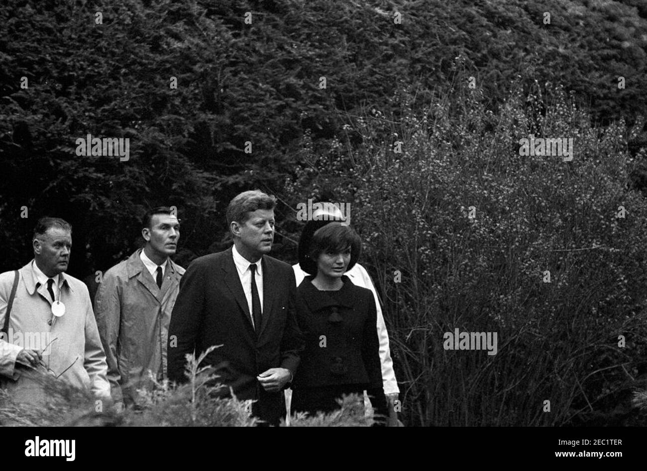 Funeral services for Mrs. Eleanor Roosevelt, Hyde Park, New York. President John F. Kennedy and First Lady Jacqueline Kennedy attend the funeral of Eleanor Roosevelt in the rose garden on the Roosevelt estate in Hyde Park, New York. Newsreel photographer for United Press Movietone, Thomas J. Craven, Sr., and White House Secret Service agent, Bob Lilley, walk at left. Stock Photo