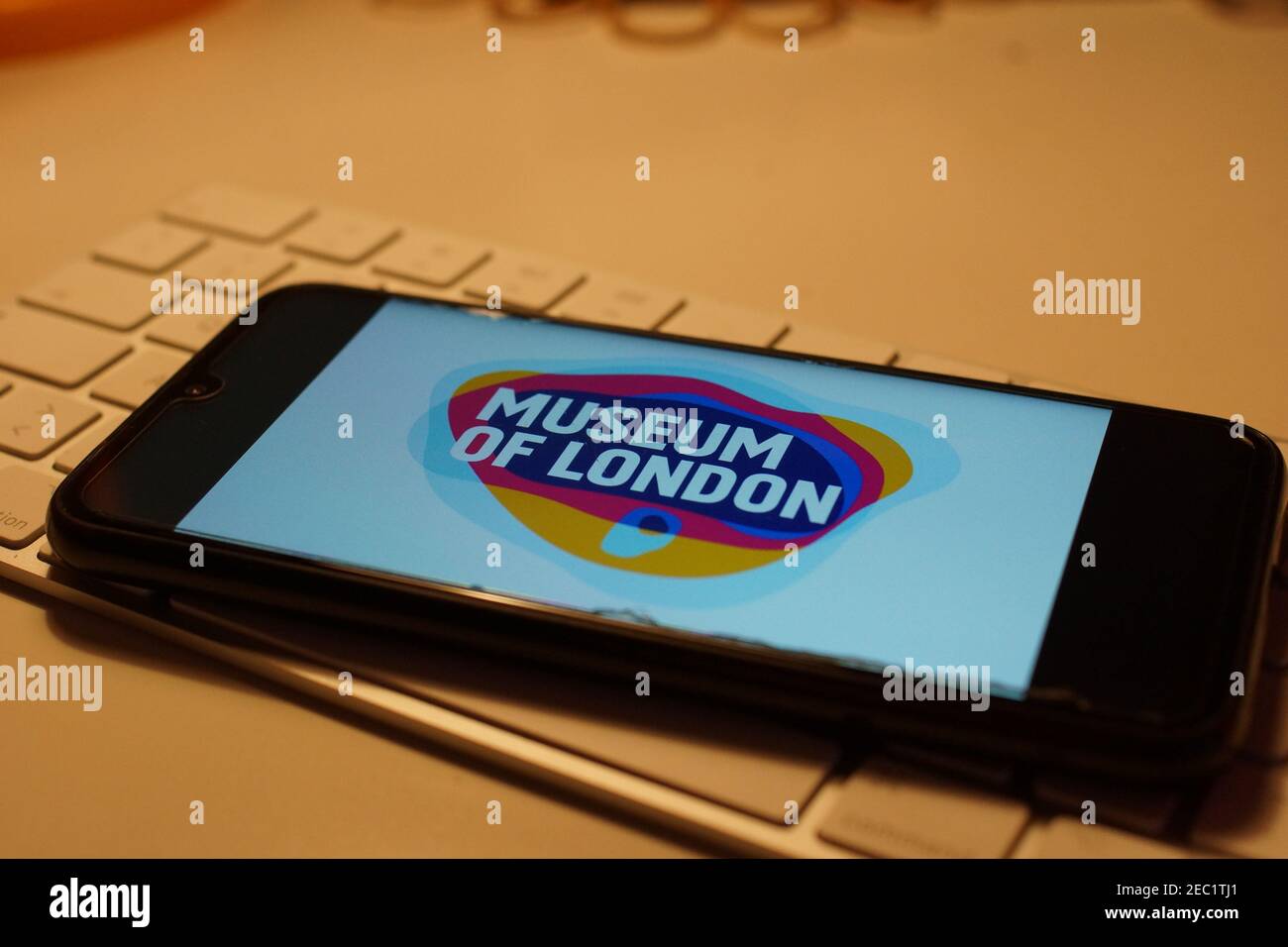 Smartphone with Museum of london logo on computer keyboard Stock Photo