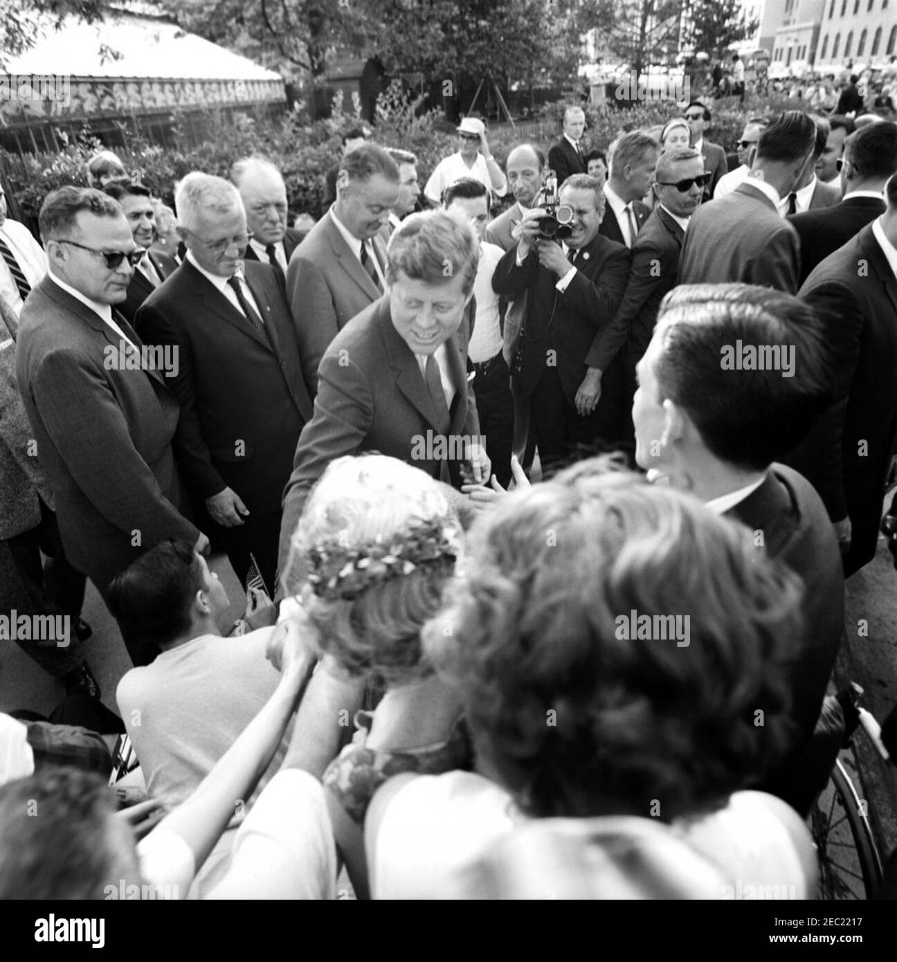 Trip to New York and Connecticut: New York City, President John F. Kennedy Visits with Patients at the Institute of Physical Medicine and Rehabilitation, New York University Medical Center, 5:45PM. President John F. Kennedy greets patients after visiting his father, Ambassador Joseph P. Kennedy, Sr., at the Institute of Physical Medicine and Rehabilitation at New York University Medical Center; Founder and Director of the Institute, Dr. Howard A. Rusk, stands behind President Kennedy. Also pictured: White House Secret Service agents, Floyd Boring and Toby Chandler. New York City, New York. [Ph Stock Photo