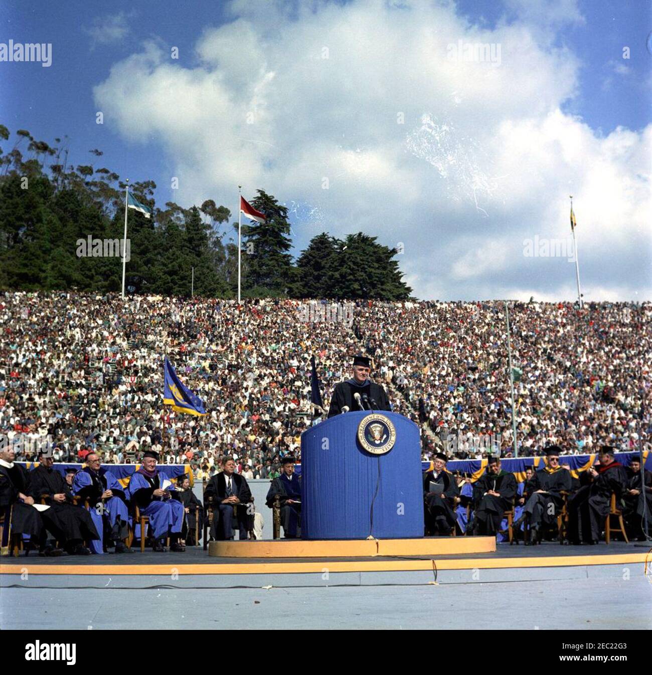 Trip to California: Charter Anniversary Ceremony, University of California at Berkeley, 1:40PM. Newly-inaugurated Chancellor of the University of California at Berkeley, Edward W. Strong, speaks at the Universityu2019s 94th Charter Day Ceremony. Seated in first row (L-R): Unidentified; Governor of California, Edmund G. u201cPatu201d Brown; University of California regent, Dr. Edwin W. Pauley; President John F. Kennedy; President of the University of California, Dr. Clark Kerr; former President of the University of California, Dr. Robert Gordon Sproul (right of lectern); three unidentified m Stock Photo