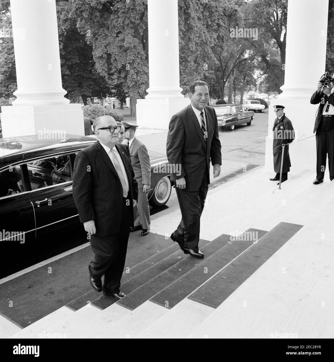 Luncheon in honor of Roberto F. Chiari, President of Panama, 1:00PM. Members of the official party of President of Panama, Roberto F. Chiari, arrive at a luncheon in honor of President Chiari. Left to right: unidentified; owner of Radio Programas Continentales (Continental Radio Programs), Fernando Eleta (mostly hidden); unidentified (standing at car); and former President of Panama, Ricardo Arias Espinosa. North Portico, White House, Washington, D.C. [Photograph by Harold Sellers] Stock Photo