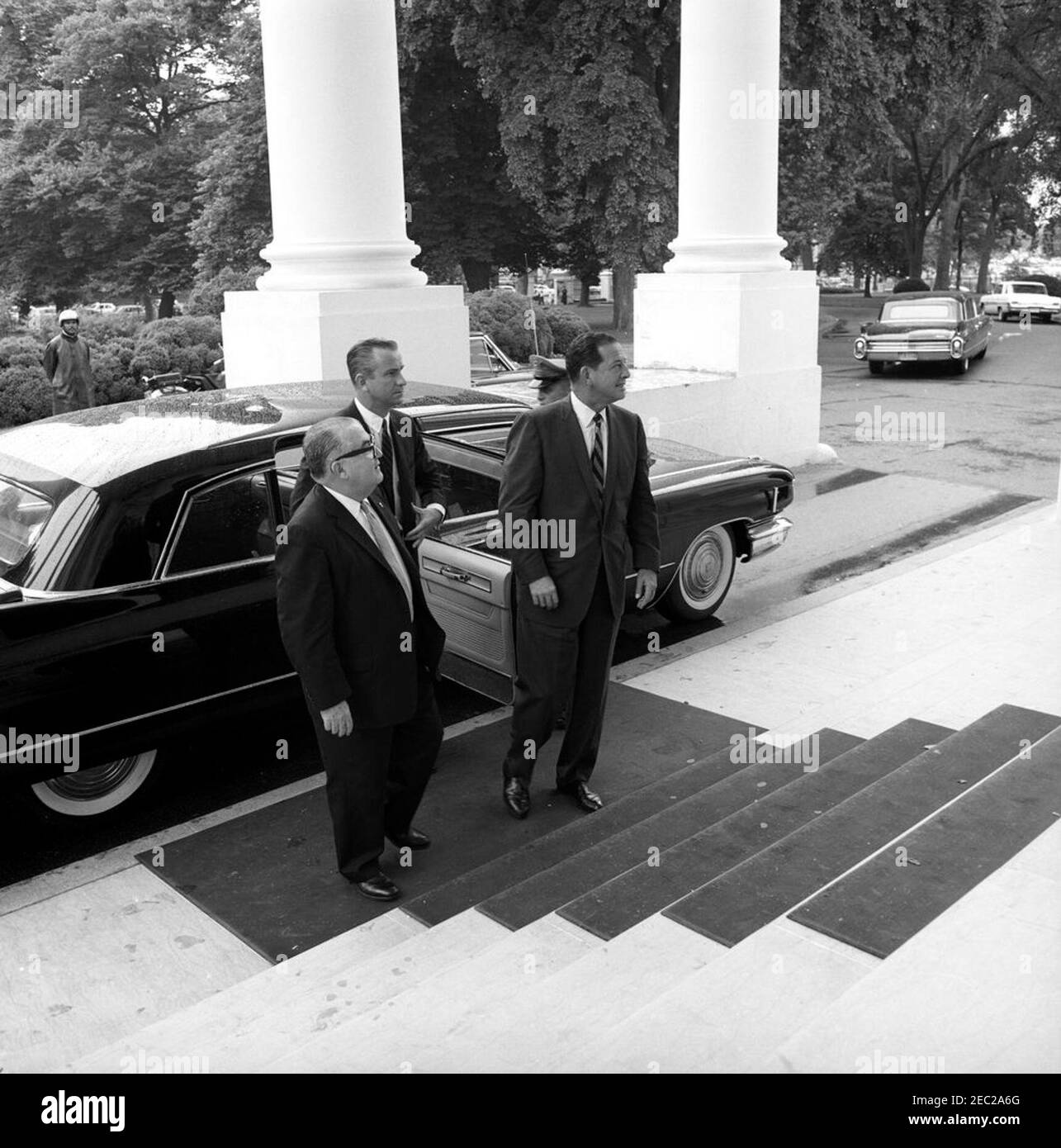 Luncheon in honor of Roberto F. Chiari, President of Panama, 1:00PM. Members of the official party of President of Panama, Roberto F. Chiari, arrive at a luncheon in honor of President Chiari. Left to right: unidentified; owner of Radio Programas Continentales (Continental Radio Programs), Fernando Eleta (exiting car); and former President of Panama, Ricardo Arias Espinosa. North Portico, White House, Washington, D.C. [Photograph by Harold Sellers] Stock Photo