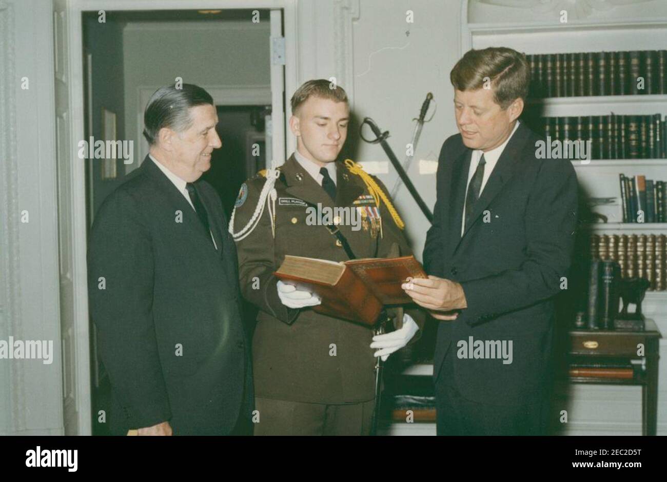 Visit of Lt. Col. Terry Entner, a Calumet (Illinois) High School Reserve Officersu2019 Training Corps (ROTC) Cadet and Congressman William T. Murphy (Illinois), 10:19AM. President John F. Kennedy receives a leather-bound collection of the works of William Shakespeare from Lieutenant Colonel Terry Entner (center), a cadet in the Reserve Officersu2019 Training Corps (ROTC) at Calumet High School in Chicago, Illinois; Representative William T. Murphy (Illinois) stands at left. Oval Office, White House, Washington, D.C. Stock Photo