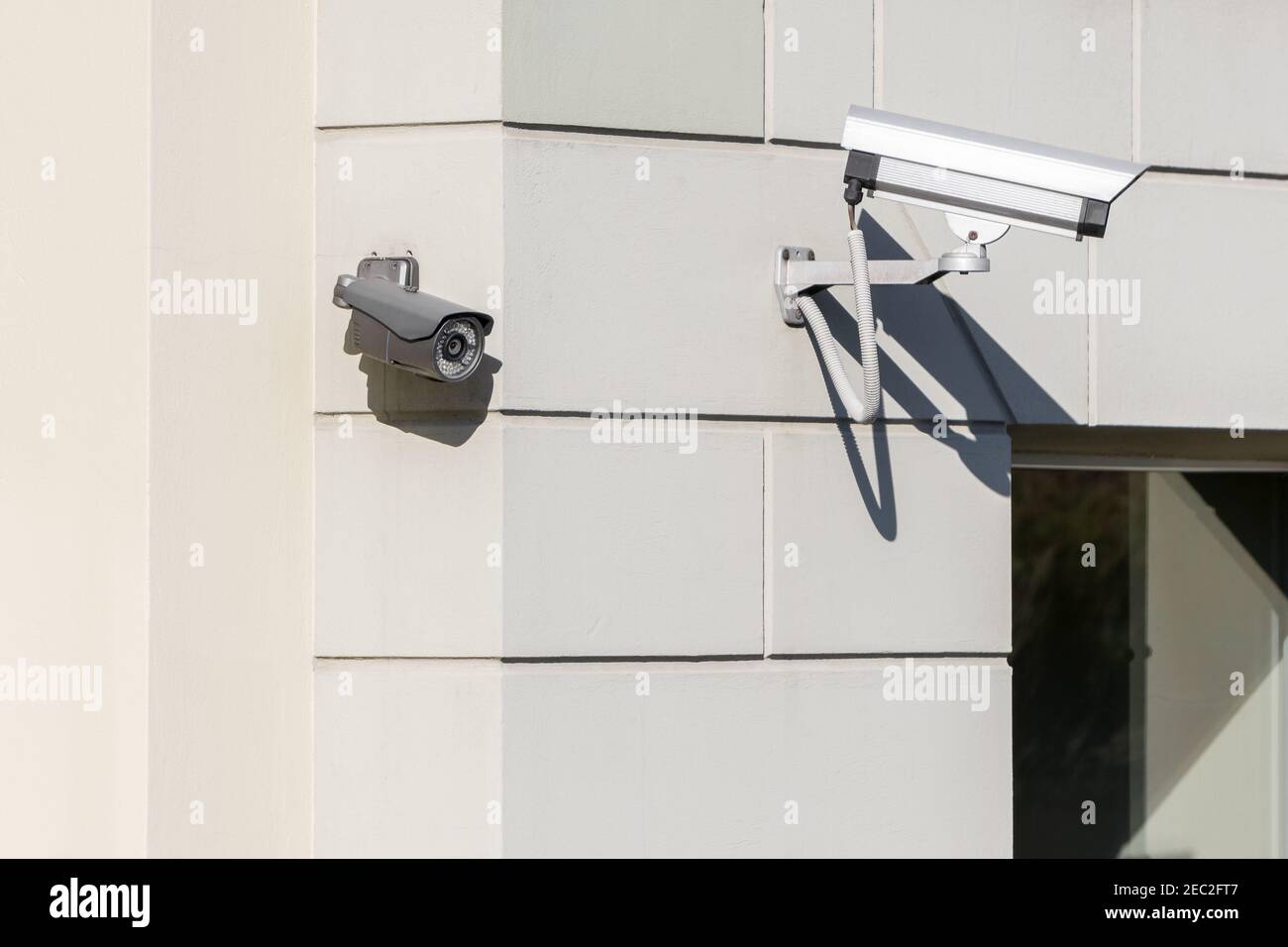 Modern CCTV cameras installed on building wall in city. Concept of surveillance and monitoring. Stock Photo