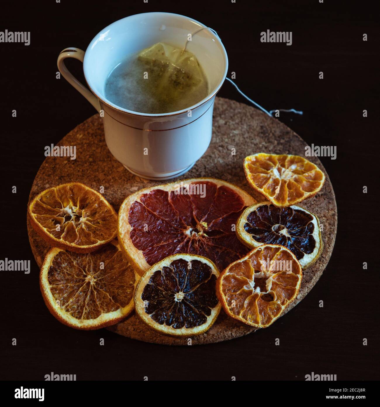 Cup of tea served with dried slices of lemons on a wooden board Stock Photo