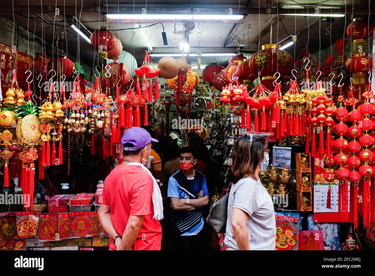 Ongpin St., Binondo, Manila, Philippines. 13th Feb, 2021. People looking at lucky charms to buy in Ongpin St., Binondo, during the Chinese New Year. Binondo is known as the oldest chinatown in the world, majority of celebrations such as dragon and lion dances were cancelled due to the pandemic. Credit: Majority World CIC/Alamy Live News Stock Photo