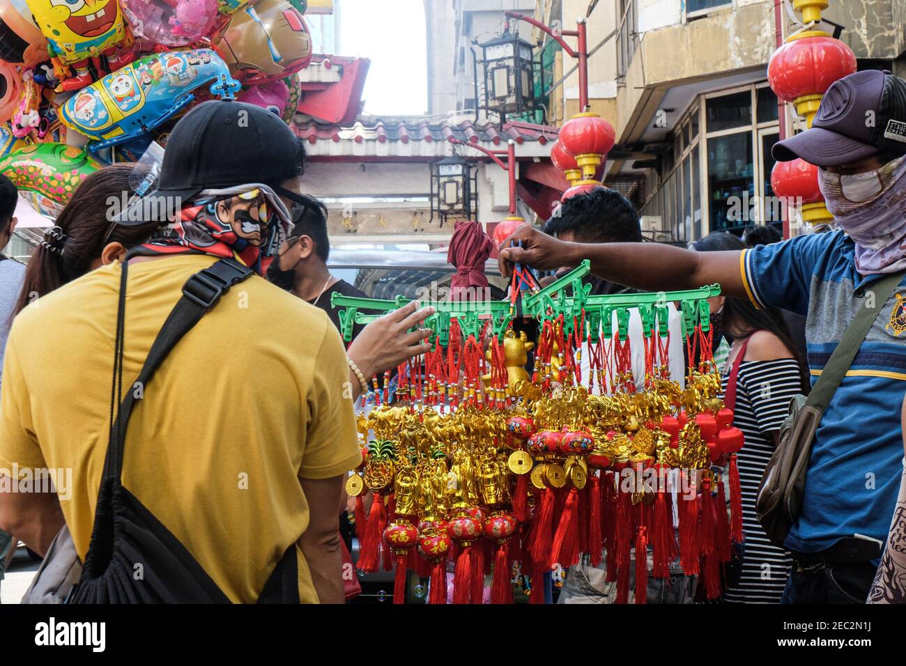 Ongpin St., Binondo, Manila, Philippines. 13th Feb, 2021. People looking at lucky charms to buy in Ongpin St., Binondo, during the Chinese New Year. Binondo is known as the oldest chinatown in the world, majority of celebrations such as dragon and lion dances were cancelled due to the pandemic. Credit: Majority World CIC/Alamy Live News Stock Photo