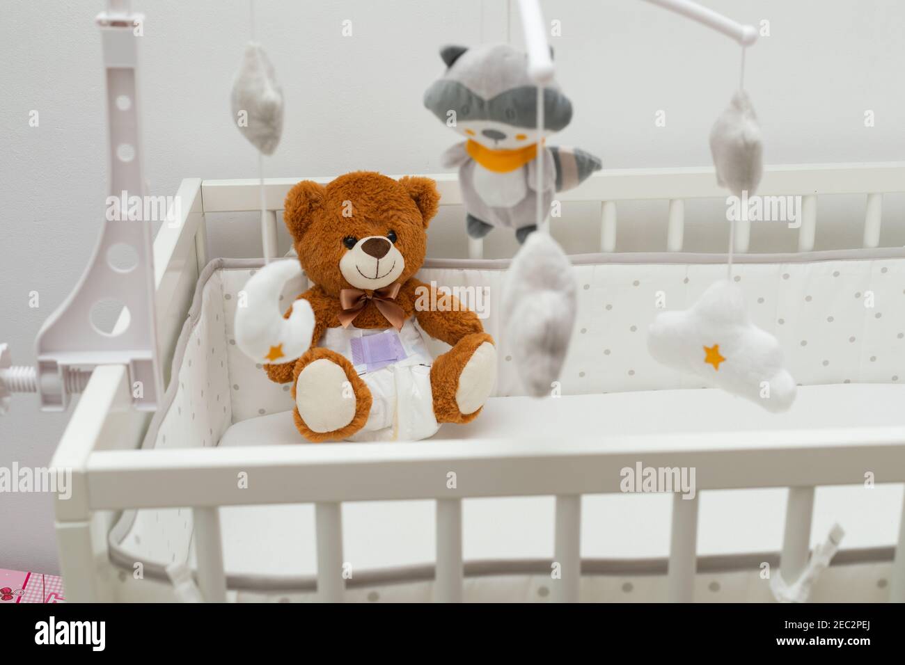 Pcture of a brown teddy bear with diaper on sitting in baby bed Stock ...