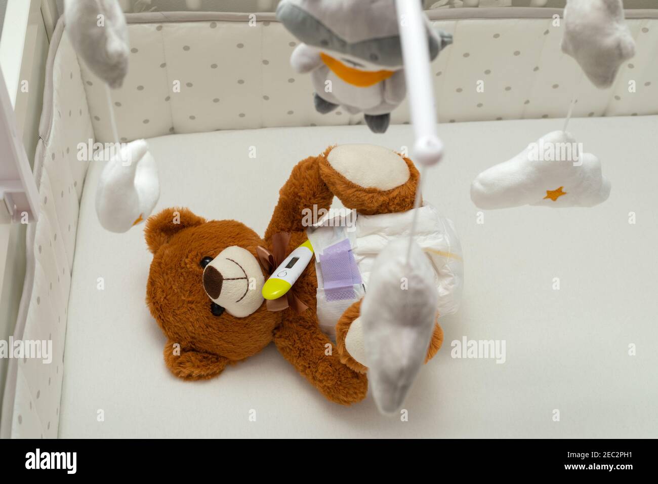 Brown teddy bear with diaper on sitting in baby bed Stock Photo - Alamy
