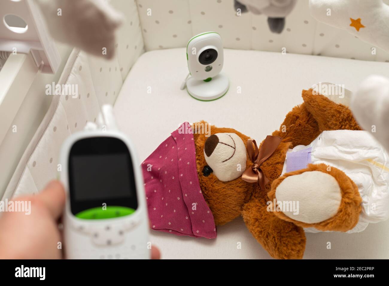 Picture of a baby monitor, camera and a teddy bear in child room Stock
