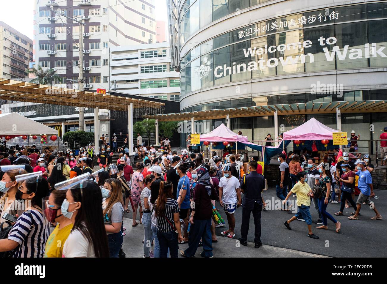 Ongpin St., Binondo, Manila, Philippines. 13th Feb, 2021. People wearing face masks and face shields walk along the streets adorned with Chinese lanterns in Ongpin, Binondo during the celebration of Chinese New Year. Binondo is known as the oldest chinatown in the world, majority of celebrations such as dragon and lion dances were cancelled due to the pandemic. Credit: Majority World CIC/Alamy Live News Stock Photo