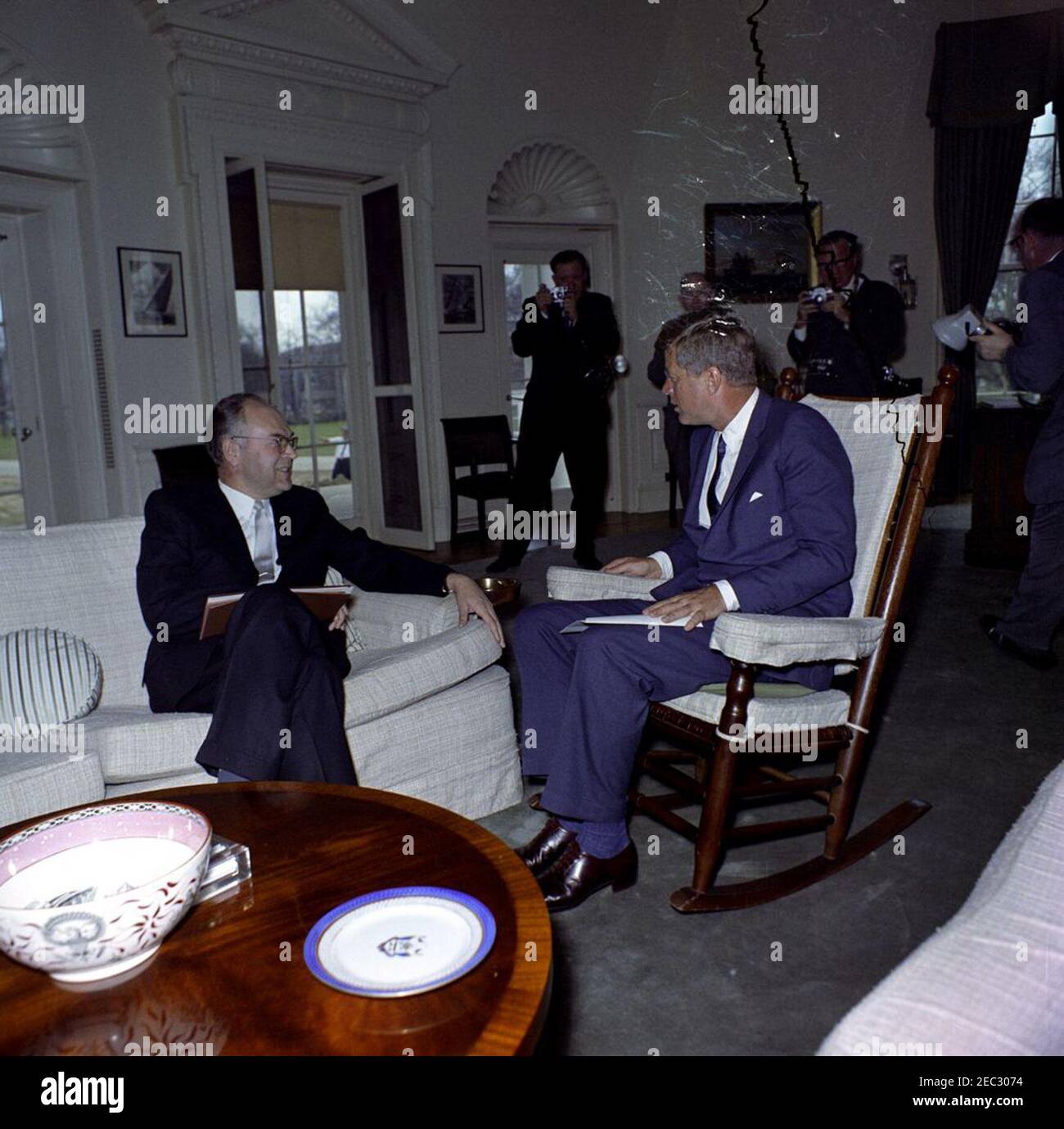 Meeting with the Ambassador of the Soviet Union (USSR), Anatoliy Fedorovich Dobrynin, 12:27PM. President John F. Kennedy (in rocking chair) meets with Ambassador of the Soviet Union (USSR), Anatoliy Fedorovich Dobrynin (left), in the Oval Office of the White House, Washington, D.C. Unidentified photographers stand in background. [Scratches and tear in upper right portion of image are original to the negative.] Stock Photo