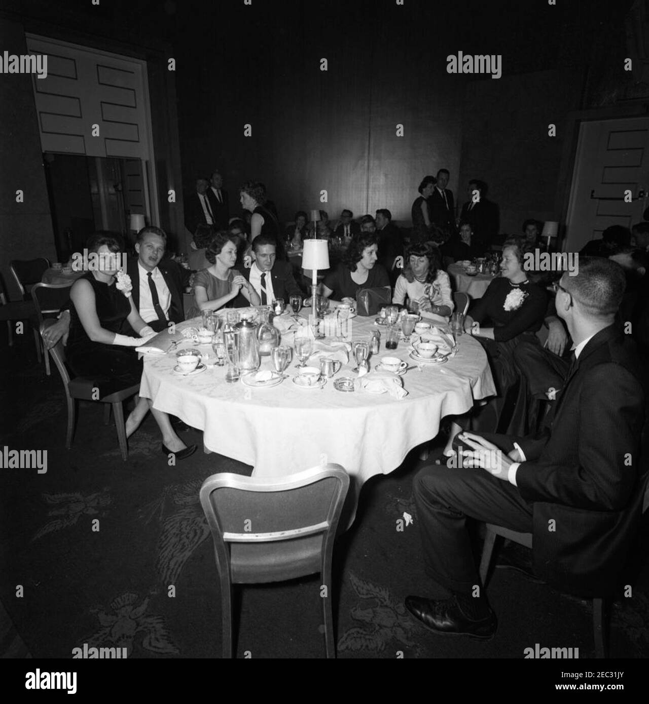 White House Communications Agency (WHCA) staff dinner party. Guests attend a dinner for White House Communications Agency (WHCA) staff. Persons in foreground are unidentified; WHCA officers Joe Taylor and Daniel S. Antinozzi stand in background. Unidentified location, Washington, D.C. [Photograph by Dan Lewis] Stock Photo