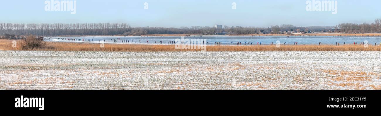 Panoramic view of ice skaters on Vogelplas Starrevaart, a lake in a polder at Leidschendam, in South Holland. the Netherlands Stock Photo