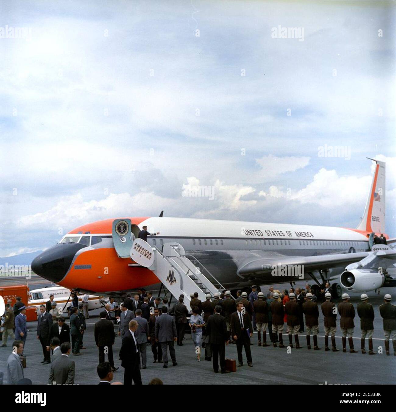 Trip to Mexico: Departure ceremonies, 11:15AM. President John F. Kennedy  waves as he and First Lady Jacqueline Kennedy (partially visible in  doorframe) board Air Force One, following their state visit to Mexico.