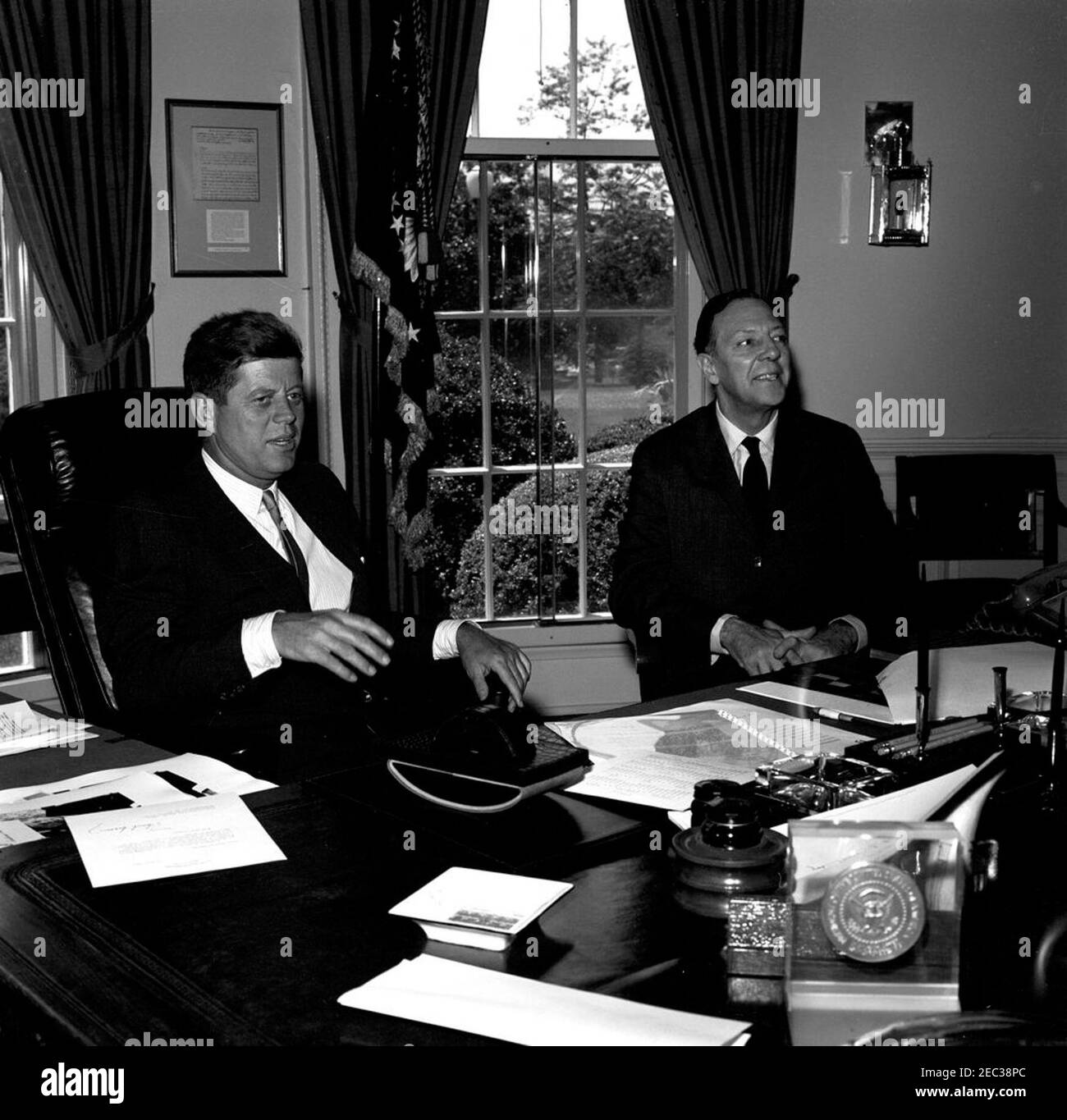 Meeting with the US Ambassador to Liberia, Charles Edward Rhetts, 12:42PM. President John F. Kennedy meets with the newly-appointed United States Ambassador to Liberia, Charles Edward Rhetts (right). Ambassador Rhetts met with President Kennedy before departing for his post. Oval Office, White House, Washington, D.C. Stock Photo