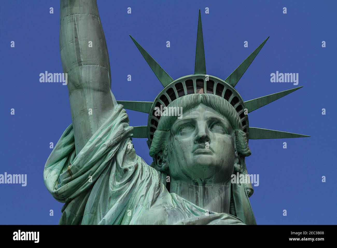 Close up view of the head of the Statue of Liberty with the crown and with the blue sky in the background Stock Photo