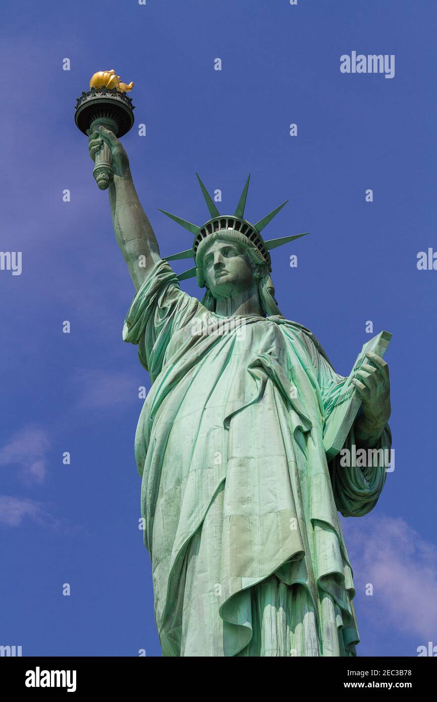 A vertical image of the Statue of Liberty in New York with the blue sky in the background on a sunny day Stock Photo