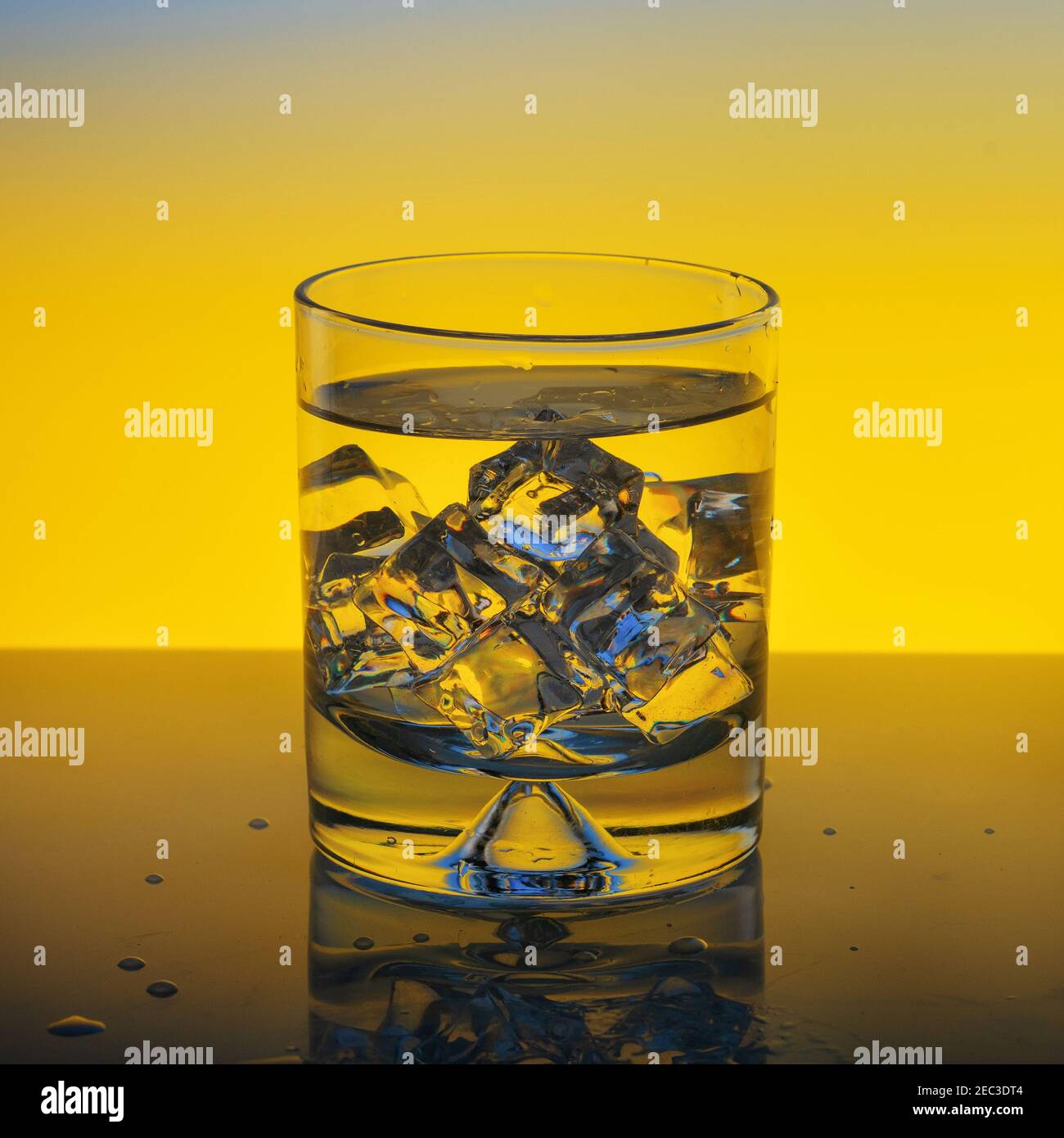 glass with water and ice on yellow background Stock Photo Alamy