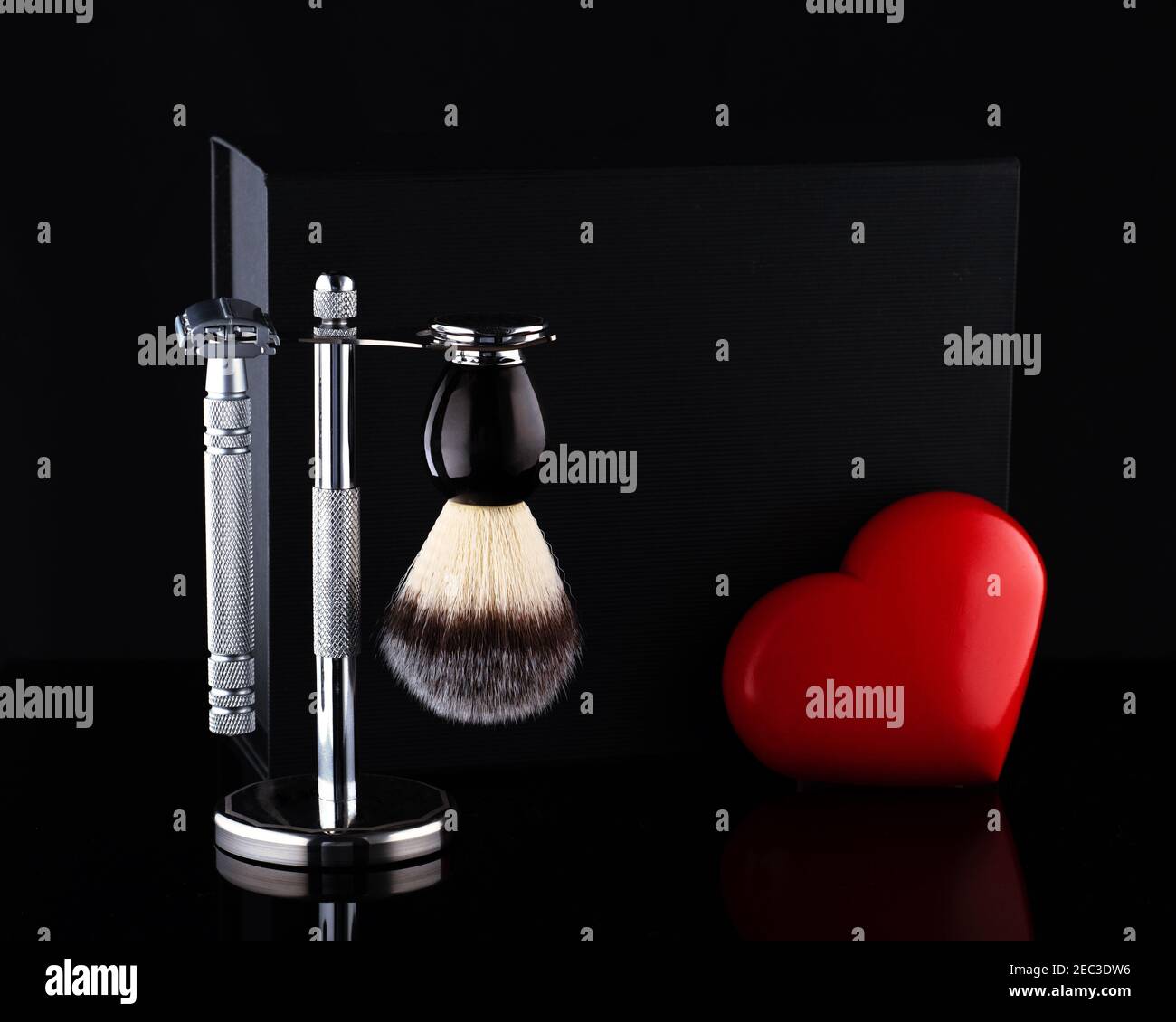 Razor and brush on stand and black box, red heart on a black ackground ...
