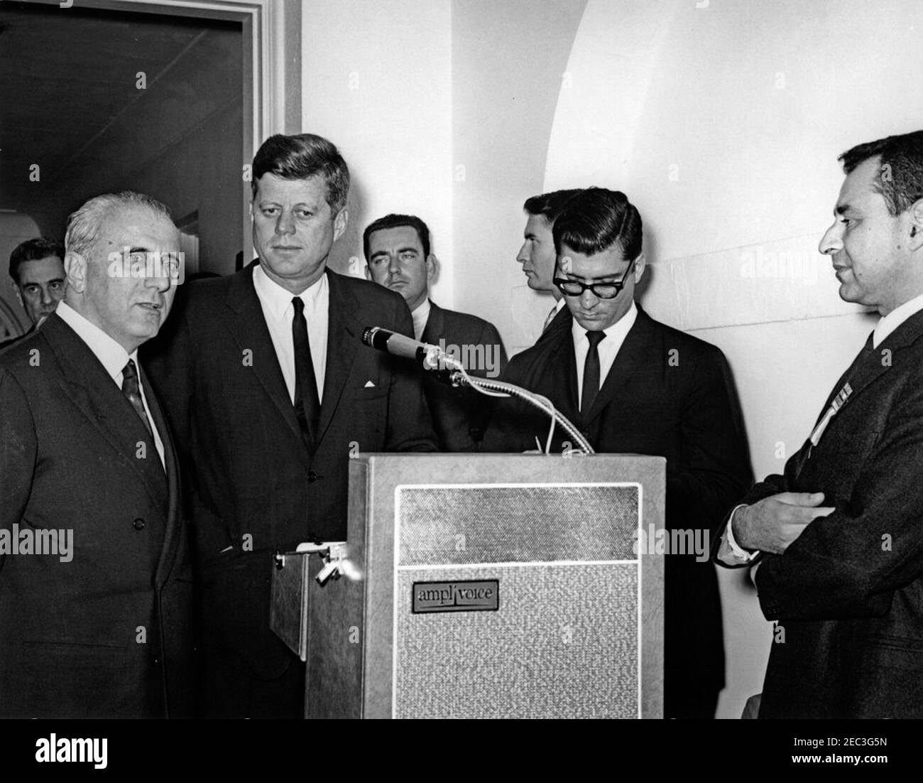 Visit of members of the u0022Incontro Club,u0022 (Marzotto family enterprises) 4:15PM. President John F. Kennedy shares the lectern with Ambassador of Italy, Sergio Fenoaltea, during an address to members of the u0022Incontro Club,u0022 part of the Marzotto family enterprises of Valdagno, Italy. In the foreground (L-R): Ambassador Fenoaltea; President Kennedy; US State Department interpreter, Neil Seidenman; and Count Giannino Marzotto. In the background (L-R): unidentified; Assistant Press Secretary, Malcolm Kilduff, Jr.; and White House Secret Service agent, Toby Chandler. West Wing Colo Stock Photo