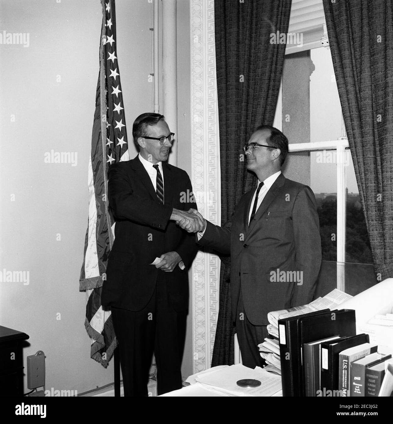Swearing-in ceremony, Gardner Ackley, Member, Council of Economic Advisers (CEA). Chairman of the Council of Economic Advisers (CEA), Walter W. Heller (left), shakes hands with Gardner Ackley at Mr. Ackleyu0027s swearing-in as a member of the CEA. Location undetermined. Stock Photo