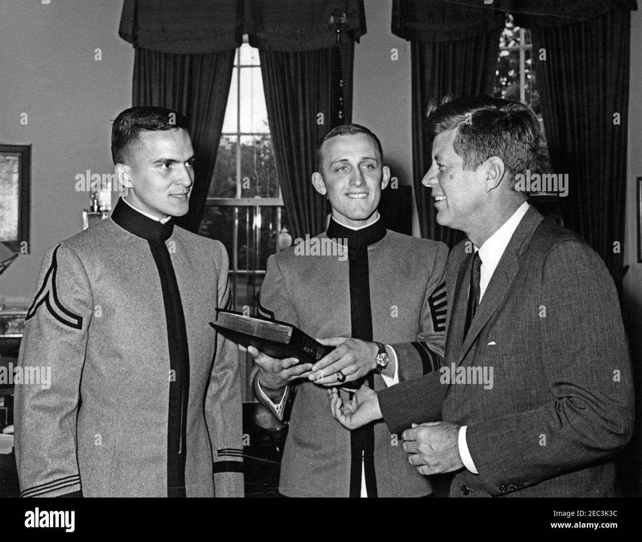 Presentation of the US Military Academy at West Point Yearbook, Howitzer, to President Kennedy, 12:12PM. United States Military Academy cadets of West Point present President John F. Kennedy with a copy of the 1963 u0022Howitzeru0022 yearbook. (L-R) Cadet David W. Knowlton, editor of the yearbook; Cadet First Captain Lyndol L. Cook, class president; and President Kennedy. Oval Office, White House, Washington, D.C. Stock Photo